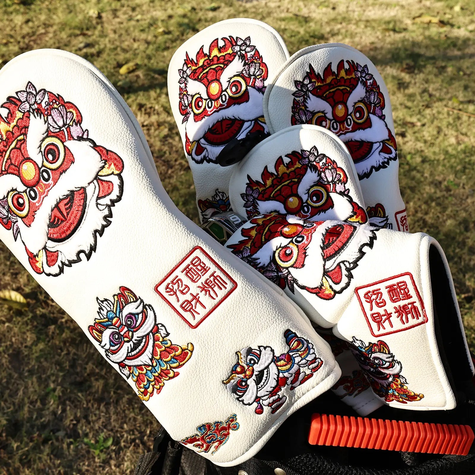 Yamato white lion golf head covers displayed on a golf course outdoors