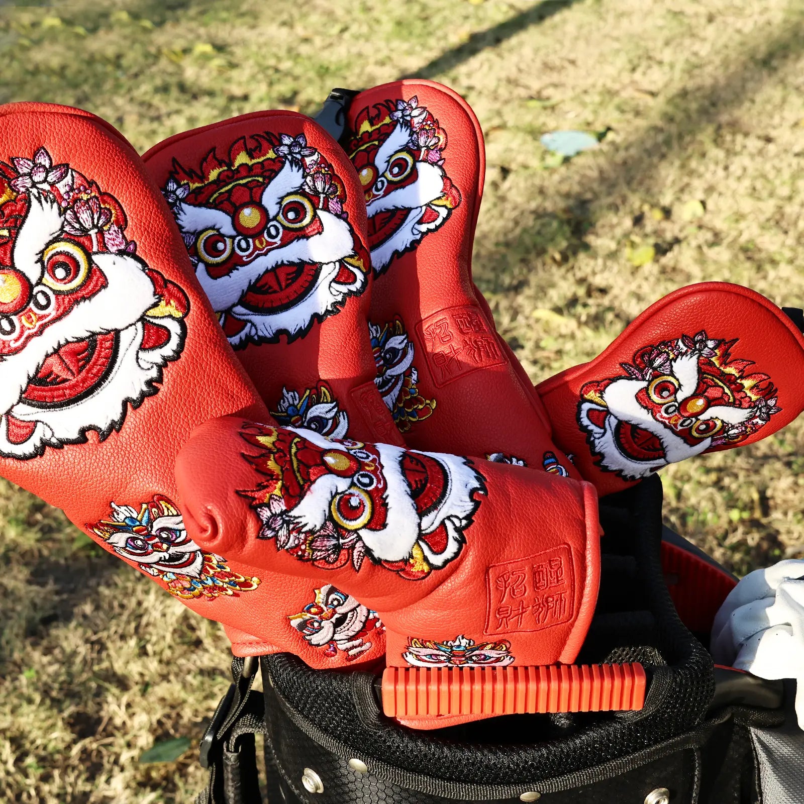 Yamato red lion golf head covers displayed on golf course outdoors