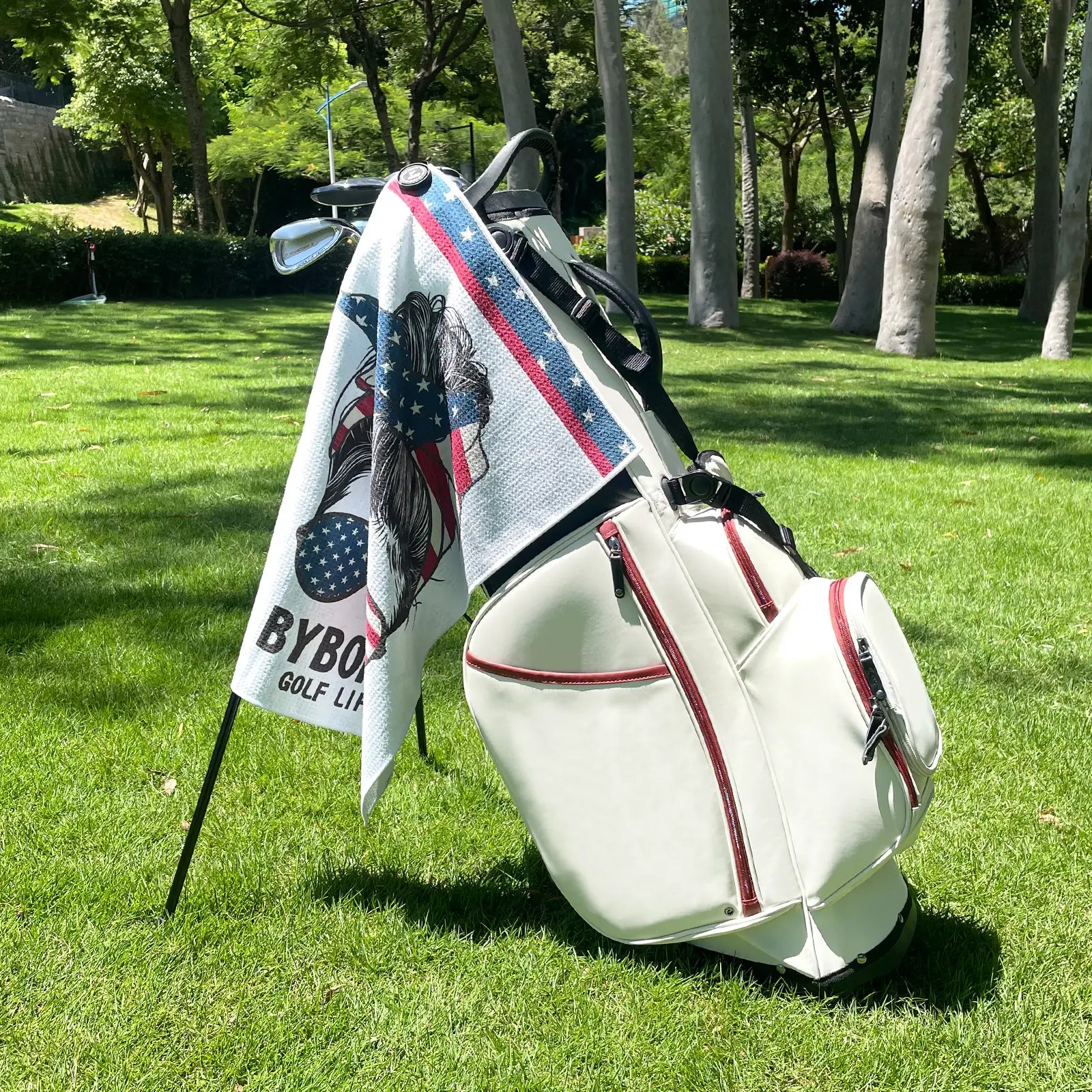 Yamato magnetic golf towel with American flag design attached to golf cart, showing strong magnet clip in use.